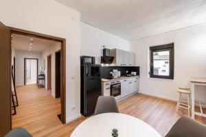 a kitchen and living room with a black refrigerator at Monteurwohnung Dresden-Klotzsche I in Dresden
