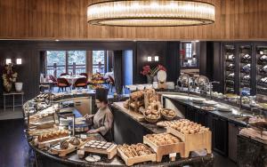 a bakery with a person preparing food in a kitchen at Apogée Courchevel, Oetker Hotels in Courchevel