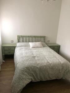 a bedroom with a bed with two nightstands and a bedspread at Casa Mario in El Fresno