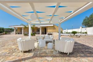 オーリアにあるVilla Artesoleの白い椅子と白い傘の下のテーブルが備わるパビリオン