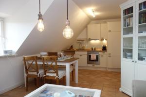 a kitchen with a table and chairs in a room at Hüs Dikstian- Wohnung 5 in Alkersum