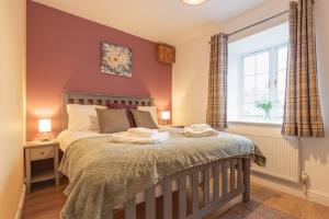 a bedroom with a bed with two towels on it at Heather Cottage - a beautiful cosy cottage for couples in Snainton