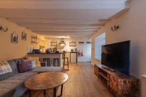 a living room with a couch and a tv and a table at Lavender Cottage - a beautiful quirky family cottage in Snainton