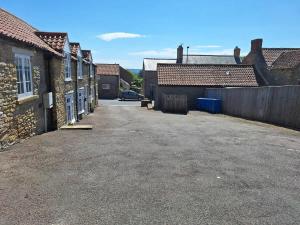 an empty parking lot between two brick buildings at Lavender Cottage - a beautiful quirky family cottage in Snainton