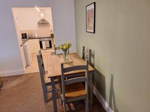 a dining room table with chairs and a vase of flowers on it at Sunflower Cottage - a charming family cottage in Snainton +7 photos