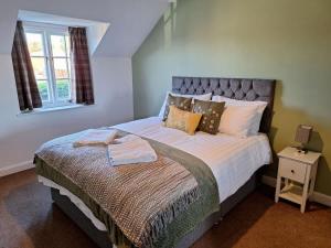 a bedroom with a large bed in a room at Dandelion Cottage - a gorgeous family cottage in Snainton