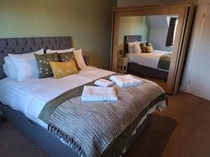 a bedroom with a bed with two towels on it at Dandelion Cottage - a gorgeous family cottage in Snainton +5 photos