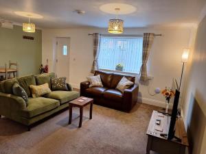 a living room with a couch and a table at Sunflower Cottage - a charming family cottage in Snainton