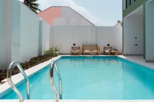 a swimming pool with chairs next to a building at Leparadis Zanzibar Boutique Hotel in Jambiani