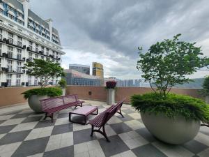 a patio with benches and potted trees and a building at MOSSAZ Minimalist Studio 2 in Petaling Jaya