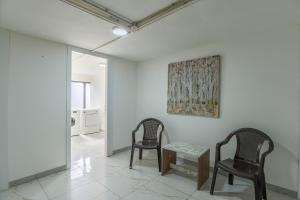 zwei Stühle und ein Tisch in einem Raum mit einem Gemälde in der Unterkunft Gate 9 Tower - Studios & Apartments in Mar Mikhael in Al Mudawwar