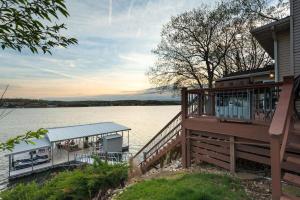 a house with a large deck next to the water at 21 Mile Marker Overlook in Osage Beach