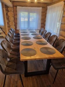 a long wooden table in a room with chairs at Cabana dintre brazi Mărișel in Dealu Negru