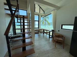 a living room with a spiral staircase and a dining room at Chaloklumbay resort2 in Mae Haad