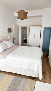 a bedroom with a large white bed and a kitchen at Monte View Apartments in Ulcinj