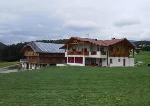 a house with a solar roof on top of a field at Appartments Radauerhof in Castelrotto