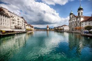 a river in the middle of a city with buildings at Boutique Hotel Weisses Kreuz - Adult only Hotel in Lucerne