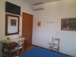 a room with a bed and a table and a mirror at B&B La Torre di Porta Maggiore in Ascoli Piceno