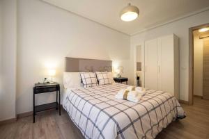 une chambre avec un lit avec un ours en peluche dessus dans l'établissement Ruedo By Silastur, à Avilés