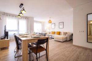 a dining room and living room with a table and chairs at Ruedo By Silastur in Avilés