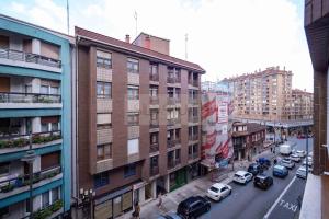 - une vue sur une rue de la ville avec des voitures garées à côté des bâtiments dans l'établissement Ruedo By Silastur, à Avilés