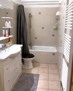 a bathroom with a tub and a toilet and a sink at Viking Koksijde appartement 8 personen in Galopen