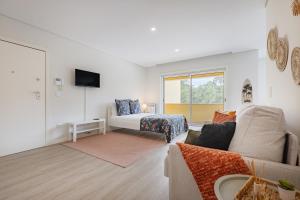 a living room with a couch and a bed at Furadouro Pine & Sea with Swimming Pool Studio 2 in Ovar