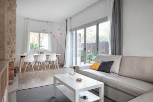 una sala de estar con un sofá y una mesa en Marina beach Castelldefels, en Castelldefels