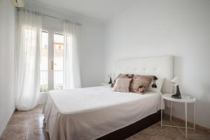 Un dormitorio blanco con una cama grande y una ventana. en Marina beach Castelldefels, en Castelldefels 22 fotos más