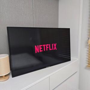 a flat screen tv sitting on top of a white cabinet at One Stay in Gwangmyeong