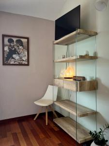 a glass book shelf in a room with a chair at La Cà di Gatt in Monteleone +43 photos