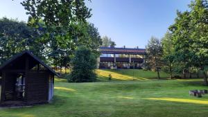 a building in the middle of a field with trees at Kambarys Šiaurėje in Kaltanėnai