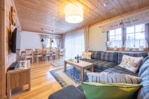 a living room with a couch and a table at Willa wakacyjna "Willa Kosibówka" z widokiem na góry dla 12 osób, sauna in Bukowina Tatrzańska