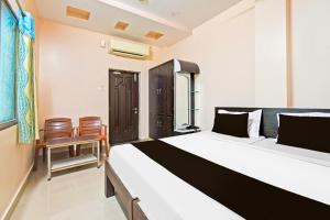Un dormitorio con una cama grande y dos sillas. en Super Hotel O Kurnool Near Kurnool Medical College, en Kurnool