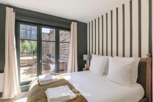 een slaapkamer met een bed en een groot raam bij La Terrasse de Pom Cozy Comfort City Center 2 Guests in Honfleur
