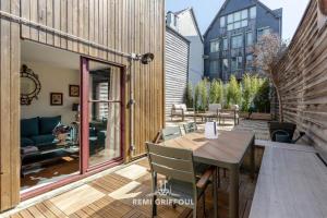 een terras met een houten tafel en stoelen bij La Terrasse de Pom Cozy Comfort City Center 2 Guests in Honfleur
