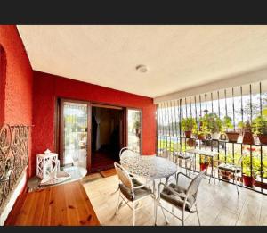 a dining room with red walls and a table and chairs at La Pedriza LA CASA DEL GALAPAGAR in Galapagar