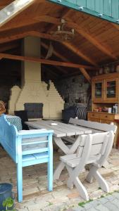 a picnic table and two chairs under a roof at Panorámaház Lovason in Lovas