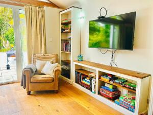 a living room with a tv and a chair at Spacious home near the Marinas with ample parking in Lymington