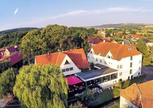 an aerial view of a large white house with red roofs at Hotel & Restaurant 5 Linden in Wickerode