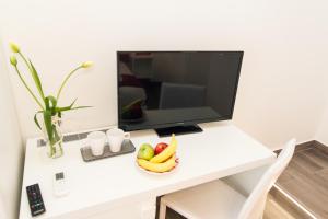 a desk with a television and a bowl of fruit on it at Sea Room Sorrento in Sorrento