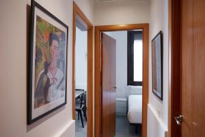 a hallway with a painting of a man on the wall at Casa tranquila cerca de Barcelona in Hospitalet de Llobregat
