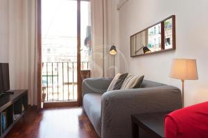 Una sala de estar con un sofá y una mesa y una ventana. en Tranquilo y luminoso apartamento en el Eixample, en Barcelona