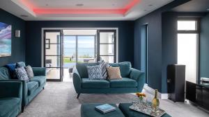 a blue living room with a couch and a table at 105 The Beach House in Penrhyn Bay