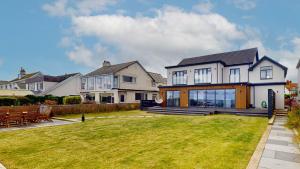 a large white house with a large yard at 105 The Beach House in Penrhyn Bay