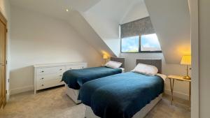 two beds in a small room with a window at 105 The Beach House in Penrhyn Bay