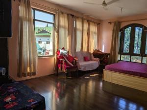 a room with a bed and a chair and a window at John's palace in Srinagar