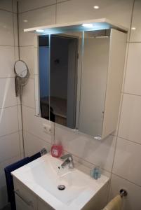 a bathroom with a white sink and a mirror at Aaltine 1 in Bad Bentheim