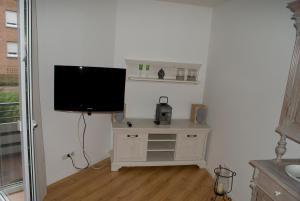 a living room with a tv and a stand with a television at Aaltine 1 in Bad Bentheim
