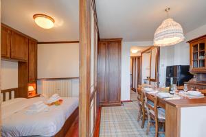 a dining room with a long table and a kitchen at Appartamento Principino 24 Ski in Ski out - Happy Rentals in Sestriere